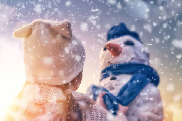 girl playing with a snowman
